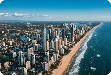 Aerial view of Gold Coast skyline and beachfront, Queensland, showcasing high-rise buildings along Surfers Paradise and the Pacific Ocean.