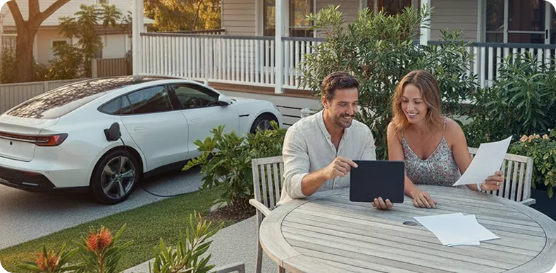 Homeowners reviewing solar rebate savings at a modern Australian home with rooftop solar panels and an electric vehicle, highlighting solar rebates, clean energy benefits, and reduced power bills.