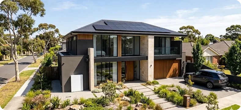 Aerial view of a suburban NSW neighbourhood with multiple homes featuring solar panel systems during sunrise, representing solar adoption and sustainability in NSW.